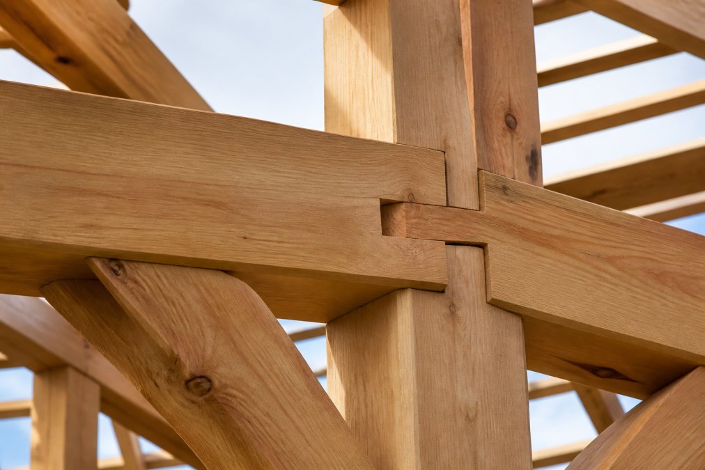 Close-up of hand-crafted wooden garage frame showing traditional mortise and tenon joinery with solid hardwood construction, demonstrating the interlocking joints and premium timber quality