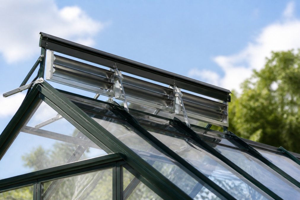 Close-up of greenhouse roof vents and louver systems with natural sunlight streaming through glass panels, showing ventilation components positioned at the peak of the structure
