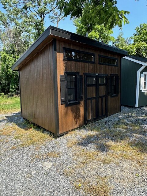S26020 10x14x8 Studio in Chestnut Brown urethane with Black trim, 40 Year Black metal roof, 5′ Double door with transoms and strap hinges, 2) 6′ Transoms, 2) 18×36 slide windows