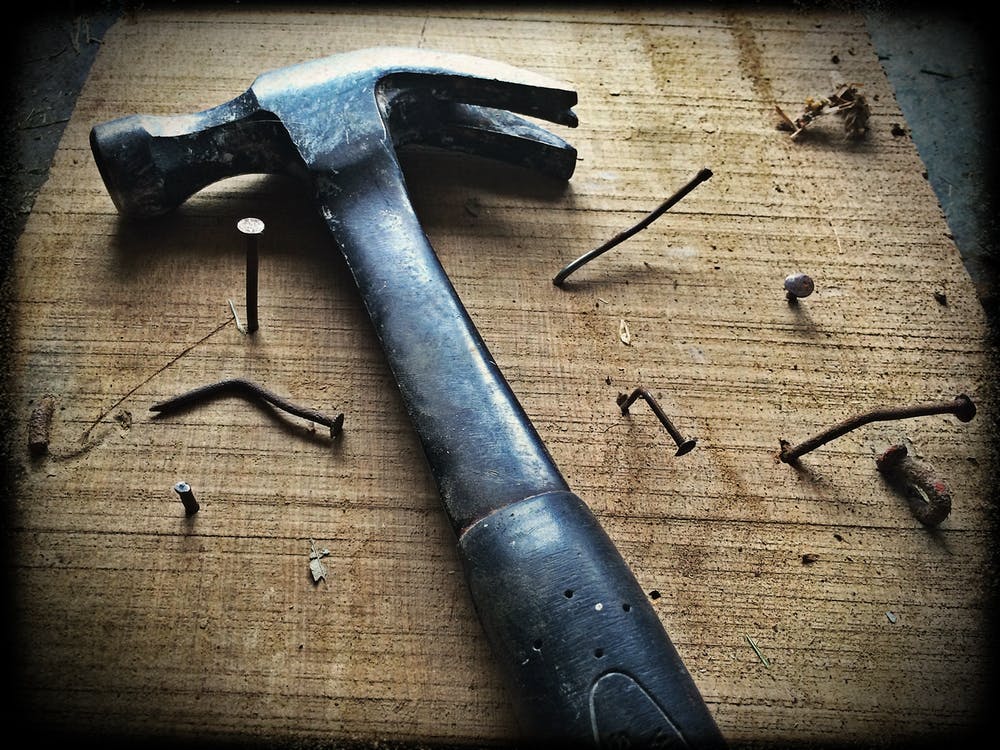 hammer laying on a table with nails